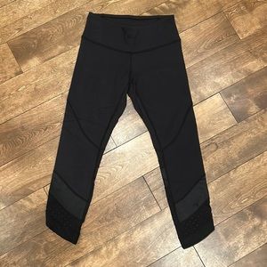 Lululemon black crop leggings with mesh detailing and asymmetrical hem. Size 4